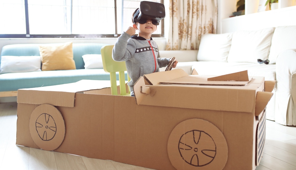copil intr-o masinuta facuta din cutii de carton cu ochelari VR