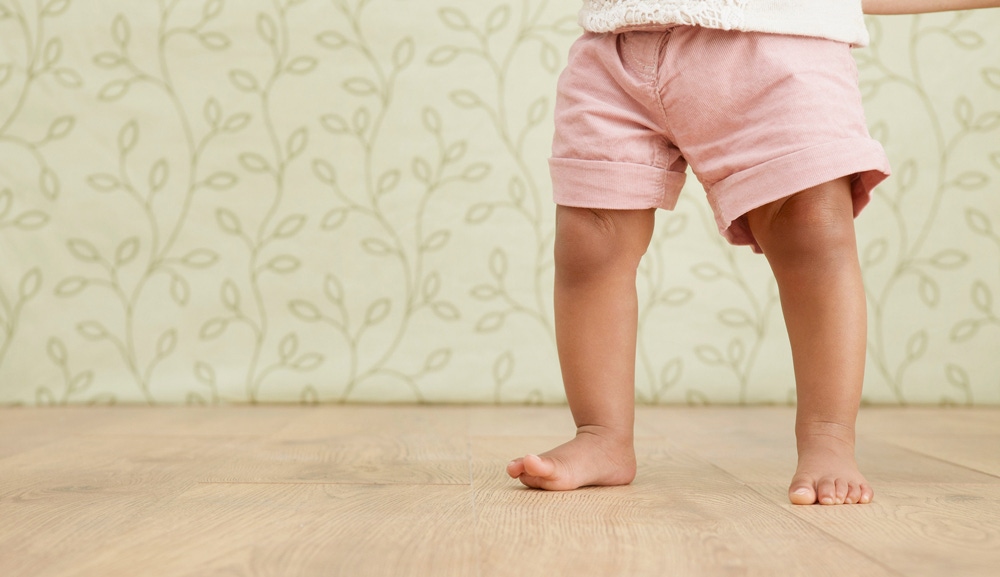 prim plan cu picioare de copil care merge pe podea