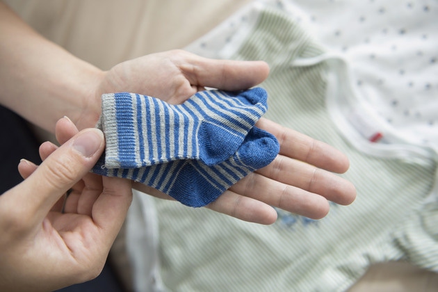 maini de femeie care tin sosete pentru copii