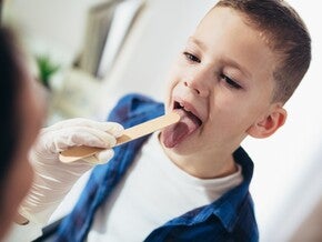 Copil cu durere in gat consultat de medic