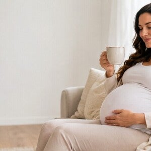 Femeie insarcinata care bea cafea