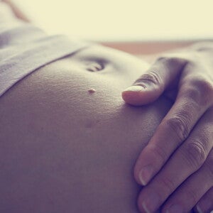 Femeie insarcinata, cu mana pe burta