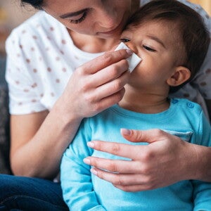 Bebeluș sters la nas de mama sa