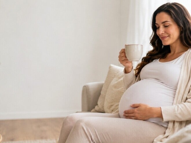 Femeie insarcinata care bea cafea