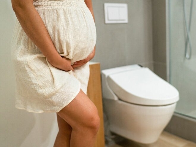 Persoană însărcinată în baie, prezentând simptome digestive frecvente în sarcină.