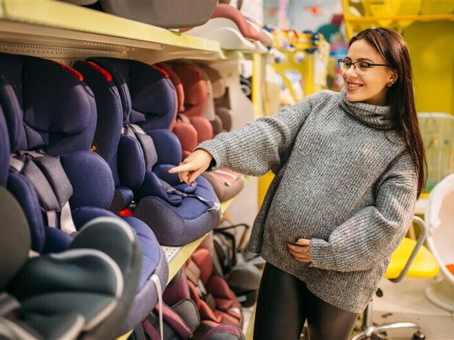 Femeie cumparand scaun auto pentru copil