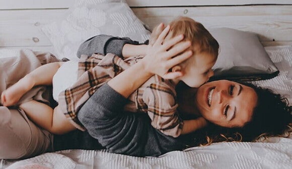 mama care sta in pat si tine copilul in brate mama care sta in pat si tine copilul in brate