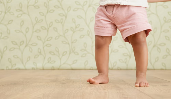 prim plan cu picioare de copil care merge pe podea