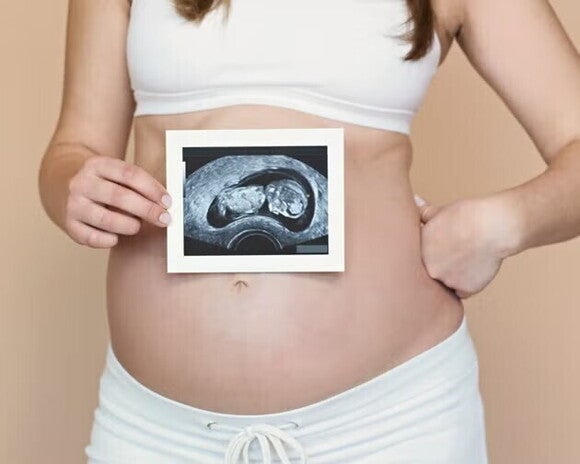 prim plan cu burtica unei femei insarcinate ce tine in mana o ecografie prim plan cu burtica unei femei insarcinate ce tine in mana o ecografie