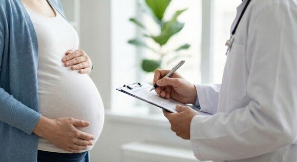 Persoană însărcinată discutând cu un medic în timpul unui control prenatal de rutină.